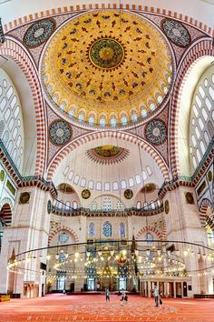 the inside of a large building with many windows and arches on it's ceiling