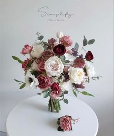 a bouquet of flowers sitting on top of a white table