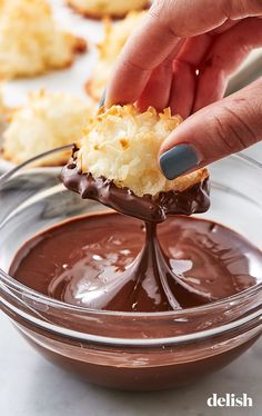 a person dipping some kind of food in a bowl with chocolate sauce on the side