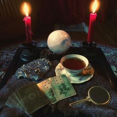 a table topped with cards and candles on top of a rug next to a mirror