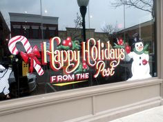 a holiday sign is in the window of a store