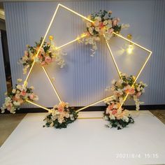 an arrangement of flowers arranged in a hexagonal frame on a white table cloth