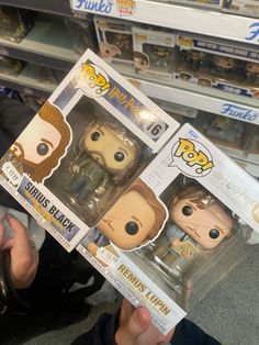 two pop - up figures are on display in a store, one is holding the box