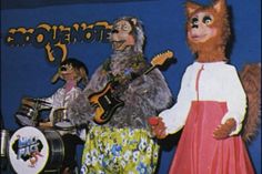 two people dressed in animal costumes standing next to each other and one person holding a guitar