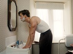 a man standing in front of a bathroom sink