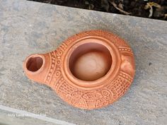 a brown vase sitting on top of a stone slab