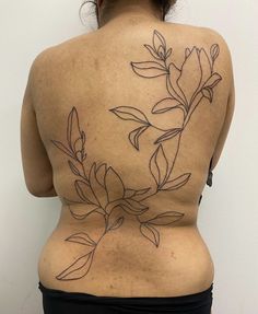 the back of a woman's body with tattoos on her lower back and side