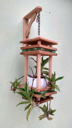 a wooden bird house with plants hanging from it's sides