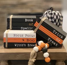 a stack of books sitting on top of a wooden table next to a black and white ribbon