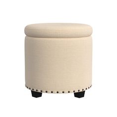 a white ottoman sitting on top of a wooden table next to a black and white stool