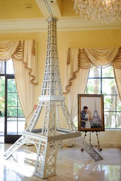 a model of the eiffel tower is on display in front of two windows