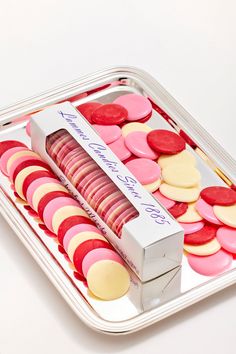 a tray filled with lots of different colored cookies