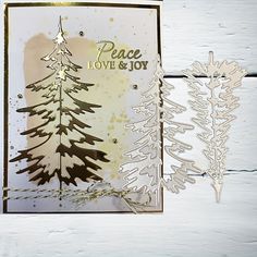 a card with some trees on it and the words peace love and joy written in gold