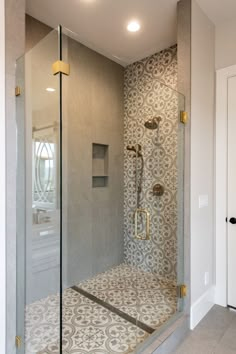 a walk in shower sitting next to a white door and wall with a glass door