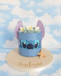 a cake that has been made to look like stitchy ears with flowers on top