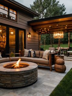 a fire pit sitting in the middle of a patio next to a large wooden building