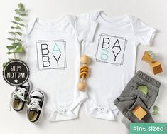 two baby onesuits with the words ba by on them next to shoes and plants