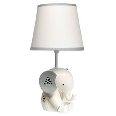 an elephant lamp with a white shade on it's head and trunk sitting next to a light