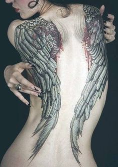 a woman with tattoos on her back and wings