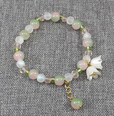 Current Processing Time is 1 to 3 business days,  Please plan accordingly. This stunning bracelet with white flower bells is accompanied by glass beads in pink, green and variegated pink and green.  A perfect accessory for Spring or Summer. Also makes a wonderful bridesmaid gift or gift for Mom.  ♥PRIORITY SHIPPING AVAILABLE♥ **High Quality, Low Price**    ♥ Bell Material: White acrylic bell flowers with glass pearls and gold plated stamen.  ♥ Bead Material: All beads are glass.  ♥ It also includes a gold plated extension for the beaded ball drop.  ♥Adjustable Length: Stretch This stretch bracelet fits most women from 6 inches to 8 inches.     ★ ★ Please contact me for larger quantities. Pink And Green Beaded Bracelets, Fnaf Bracelet, Bells Bracelet, Flower Beaded Bracelet, Flower Charm Bracelet, Bell Flowers, Green Beaded Bracelets, Beaded Ball, Spring Bracelet