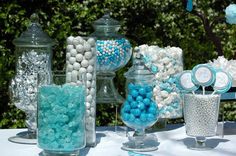 a table topped with lots of blue and white candies