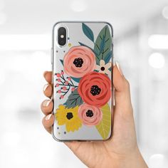 a woman's hand holding an iphone case with flowers on it