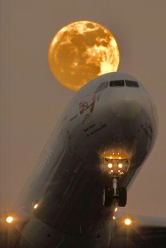 an airplane with the moon in the background