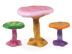 three plastic toys sitting next to each other on top of a white surface and one has a pink mushroom