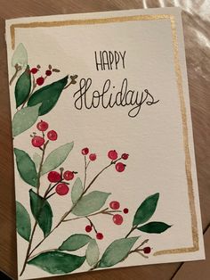 a card with watercolor leaves and berries on it that says happy holidays in gold lettering