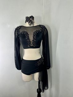 a mannequin wearing a black top and skirt