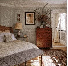 a bed sitting next to a dresser in a bedroom