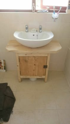 a white sink sitting on top of a wooden cabinet