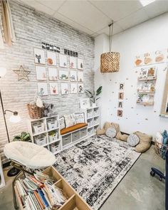 a living room filled with lots of furniture next to a white brick wall covered in pictures