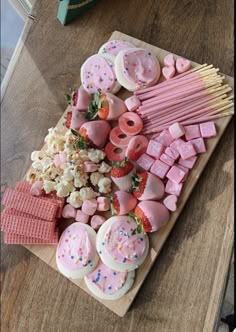 a wooden table topped with lots of different types of food and marshmallows