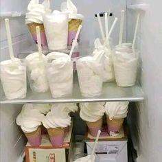 a shelf filled with lots of cupcakes covered in white frosting and paper straws