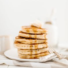 a stack of pancakes on a plate with syrup