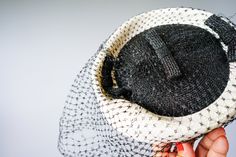 "DESCRIPTION * Vintage hat from 1950s- 1960s * pillbox style: flat indented crown, fitted to the head, brimless * made of off-white and black straw * embellished with three straw bows on top * comes with veil, it has some holes * tag reads \"Braunstein's Washington\" CONDITION * hat is in good vintage condition and shows signs of normal use. But the veil has some holes, some on the front and on the left of the hat, please see the last photo. SIZE Height: 2.5\" Hat circumference: 21\" top diamete Vintage Boater Hat For Kentucky Derby Evening, Vintage Top Hat For Royal Ascot And Church, Vintage Boater Hat With Curved Brim For Party, Vintage Fitted Boater Hat For Wedding, Vintage Curved Brim Boater Hat For Evening, Vintage Boater Hat With Short Brim For Wedding, Vintage Hat With Structured Crown For Parties, Vintage Curved Brim Cloche Hat For Weddings, Vintage Cloche Mini Hats For Royal Ascot