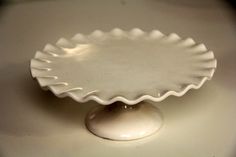 an empty white plate sitting on top of a table