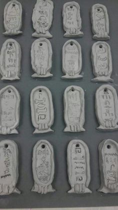 twelve tombstones with writing on them are in the shape of small heads and hands