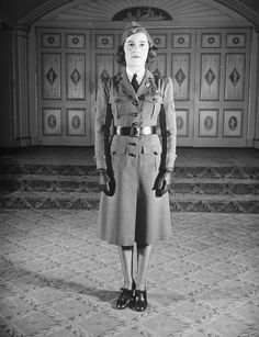 an old black and white photo of a woman in uniform