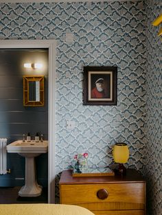 a bedroom with blue and yellow wallpaper and a sink