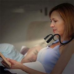 a pregnant woman reading a book while wearing a stethoscope to look at it