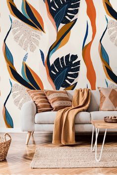 a living room with a couch, rug and wallpaper that has tropical leaves on it