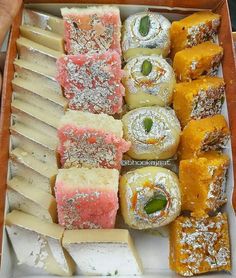 a box filled with lots of different types of pastries on top of each other