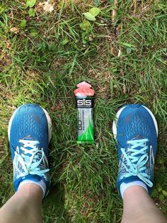 a person standing next to an energy drink in the grass