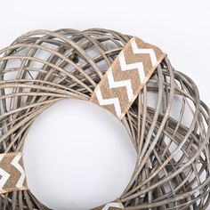 a close up of a wreath on a white background with brown and white chevron ribbon