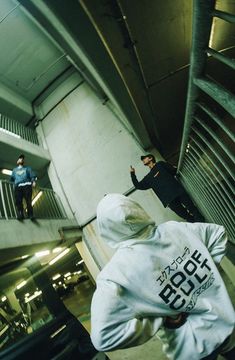 two men standing on top of a skateboard ramp in a parking garage next to each other