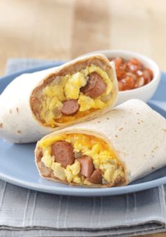 two breakfast burritos on a plate with salsa