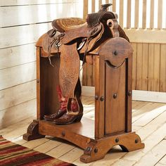 a wooden bench with a saddle and boots on it