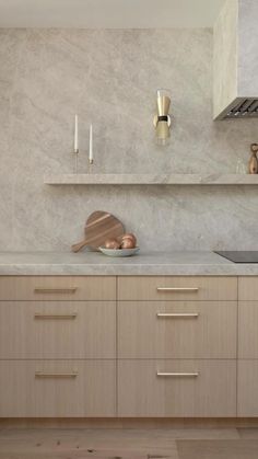 a kitchen with wooden cabinets and marble counter tops